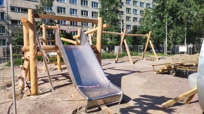 Детская деревянная площадка с горкой и качелями в процессе строительства
