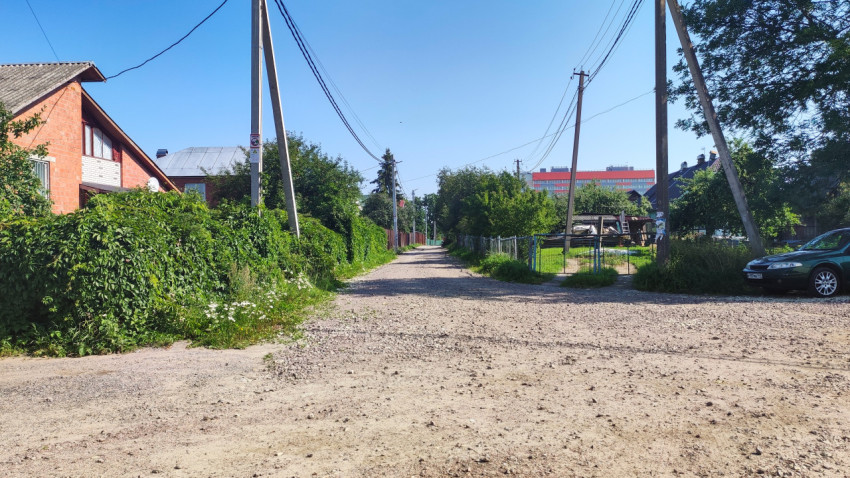 Спокойная деревенская улица с жилыми домами и зеленью