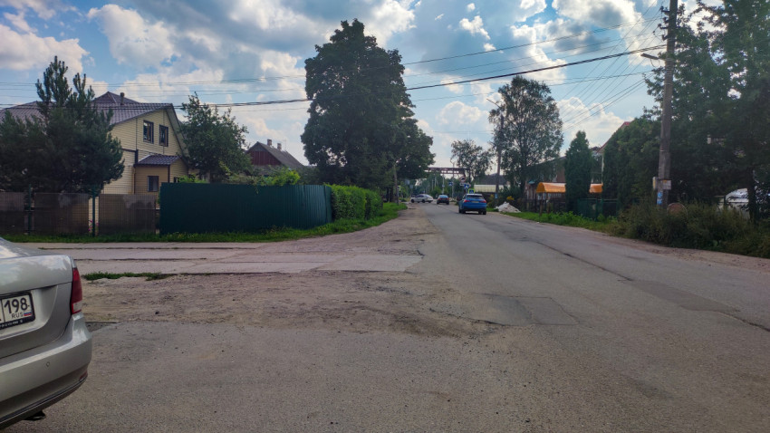 Загородная улица с жилыми домами и деревьями