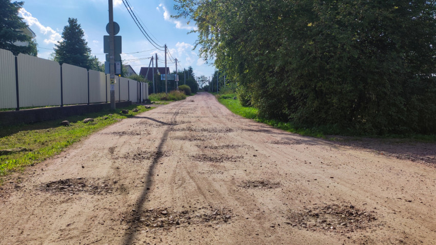 Улица в деревне с ямами и неровной поверхностью