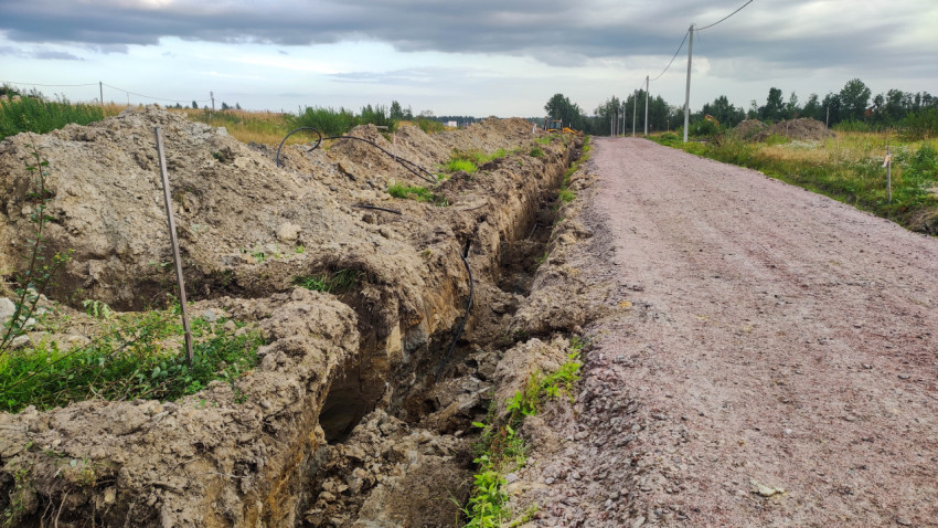 Траншея для труб водоснабжения рядом с грунтовой дорогой