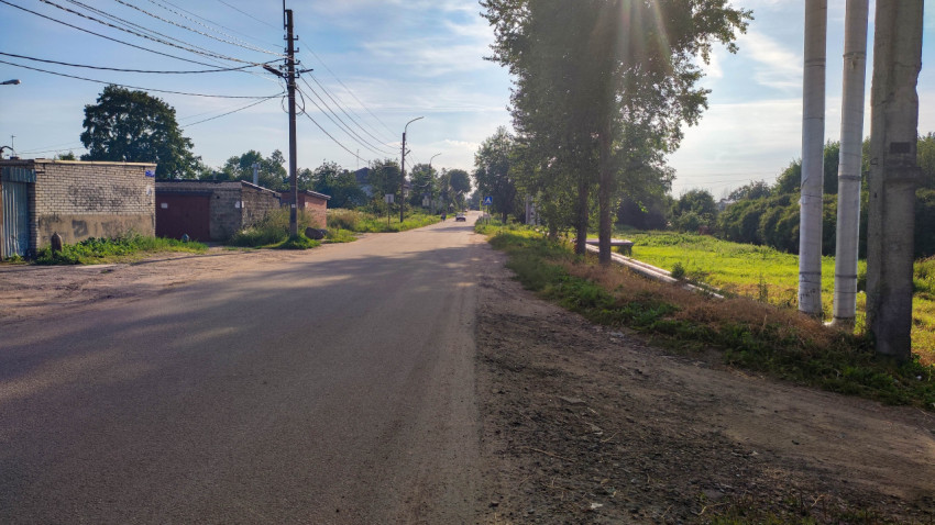 Деревенская дорога с деревьями и домами вдали