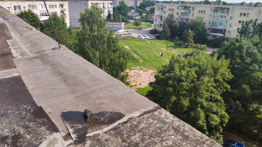 Вид с крыши на двор с деревьями, зданиями и игровой площадкой