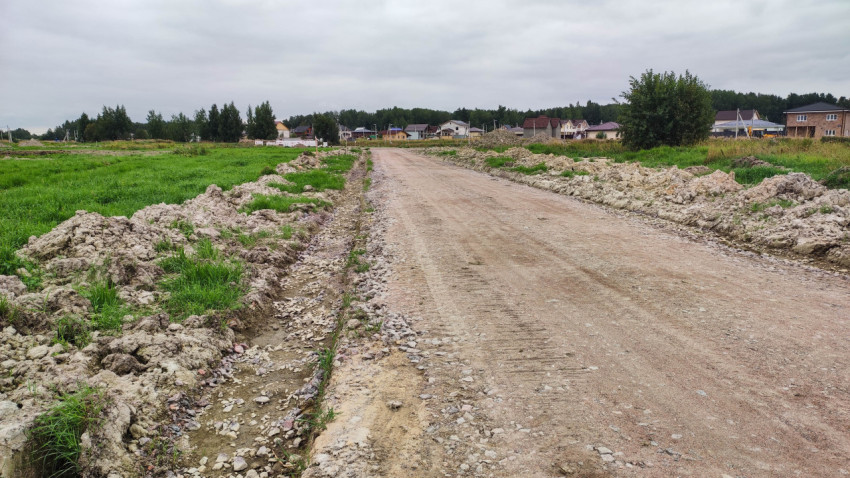 Грунтовая дорога и зеленые участки в процессе освоения