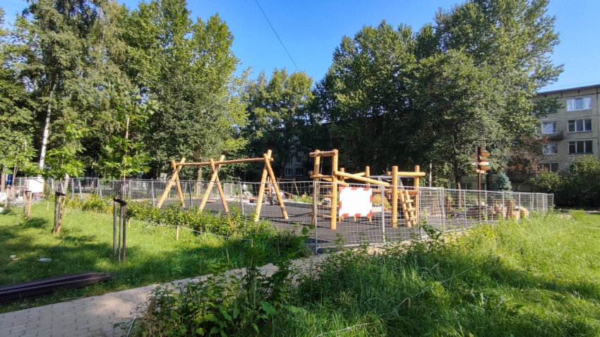 Детская площадка в парке на фоне зелёных деревьев