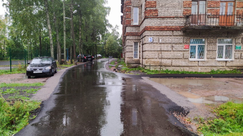 Кирпичный дом на фоне мокрой дороги в дождливую погоду