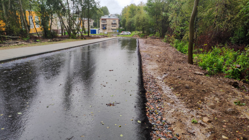 Новая асфальтированная дорога с тротуаром после дождя