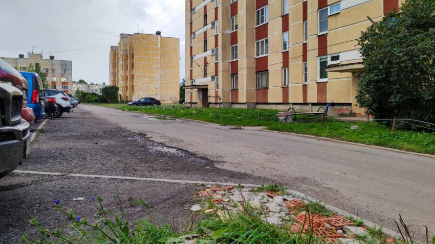 Двор с жилыми многоэтажными домами и парковкой в спальном районе города