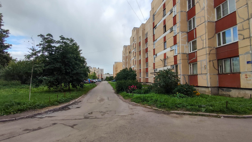 Двор с асфальтированной дорогой и многоэтажными домами в жилом районе