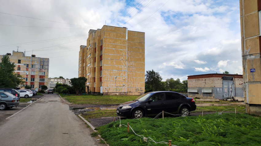 Советская панельная застройка в пригороде с припаркованными автомобилями