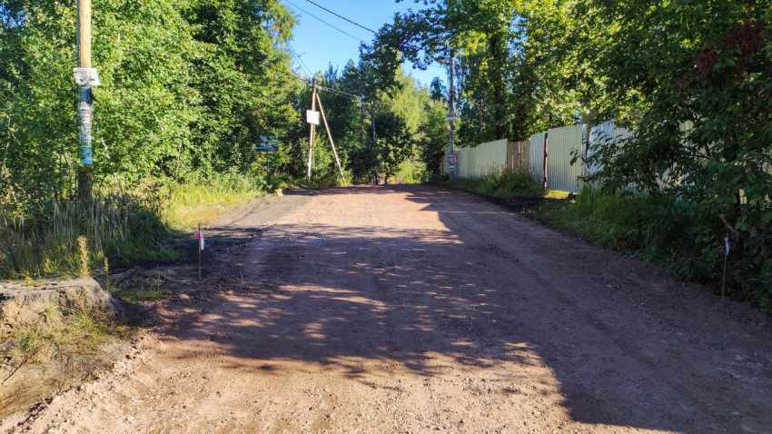 Грунтовая дорога в поселке с начатыми работами по благоустройству