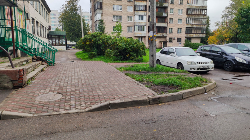 Дворовая территория с тротуарной плиткой и парковкой у жилого дома