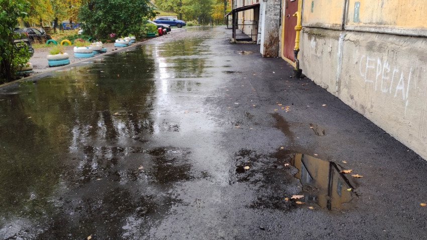 Лужи на асфальте у жилого дома
