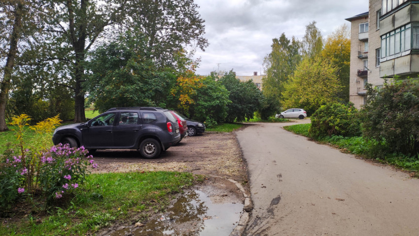 Парковка у жилого дома с осенней листвой