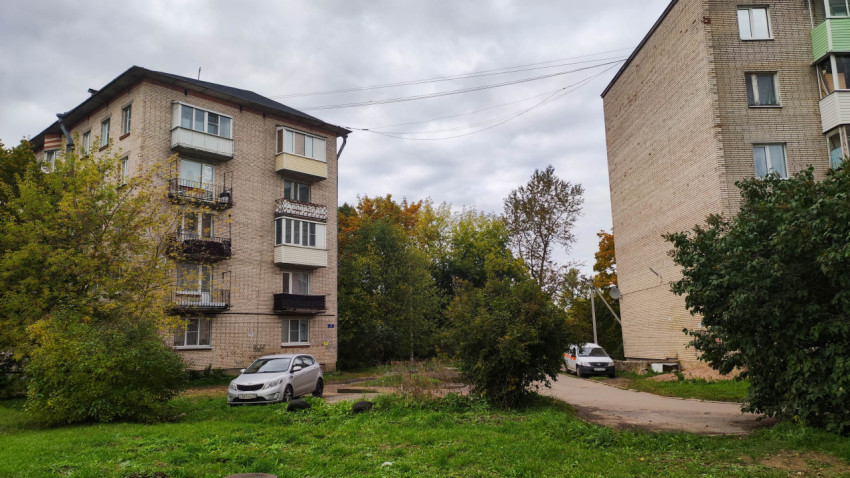 Двор между многоквартирными кирпичными домами с парковкой