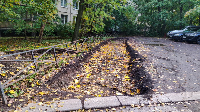 Траншея под пешеходную дорожку вдоль парковки в жилом районе