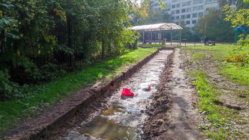 Траншея для пешеходной дорожки с застоем воды после дождя