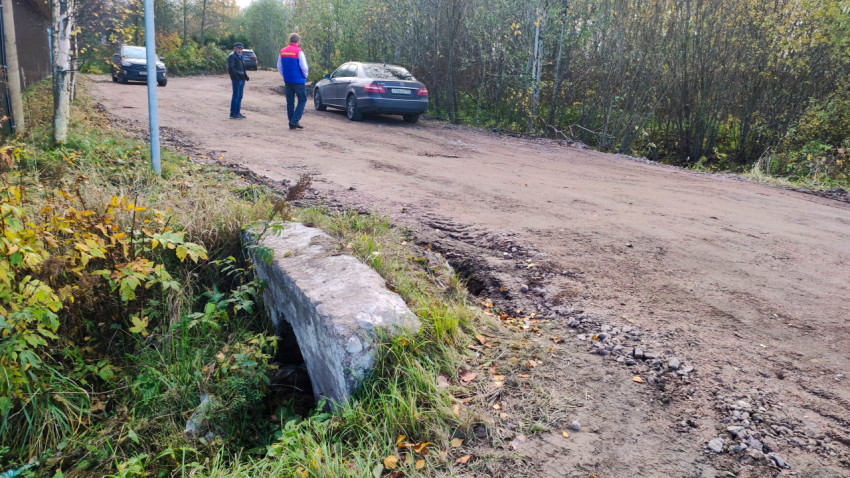 Грунтовая дорога с водопропускной трубой и людьми