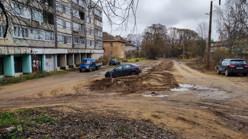 Территория после прокладки труб с разрытым грунтом и застрявшим автомобилем