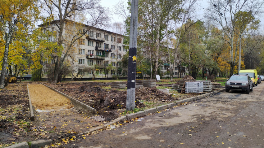 Подготовка основания пешеходной дорожки и склад строительных материалов