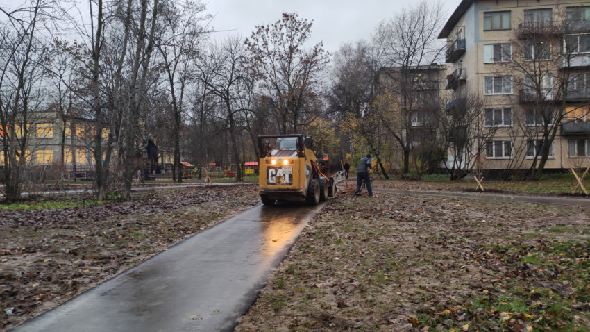 Работа строительной техники на пешеходной дорожке во дворе дома