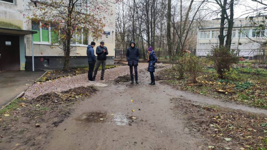 Группа людей на обследовании дворовой территории возле дома