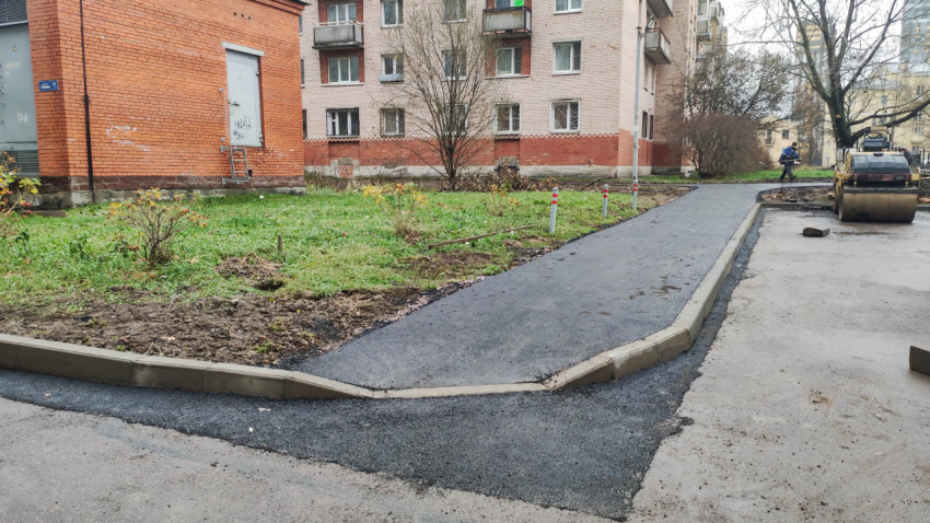 Асфальтированный тротуар с бордюрами во дворе жилого дома