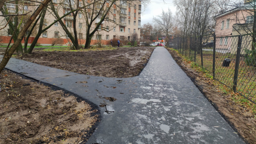 Новый асфальтированный тротуар в жилом дворе после дождя