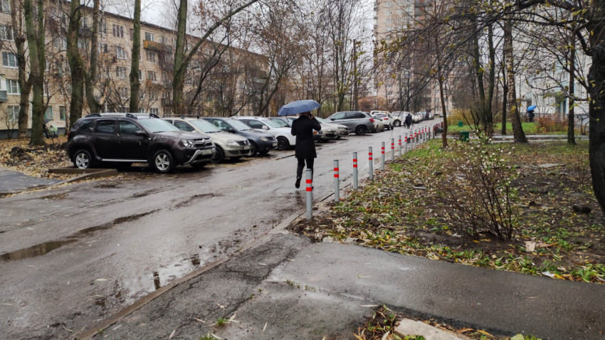 Ряд антипарковочных столбиков вдоль проезжей части во дворе жилого дома