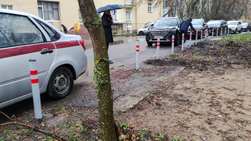 Ограничительные столбики вдоль дороги в жилом районе в дождливую погоду