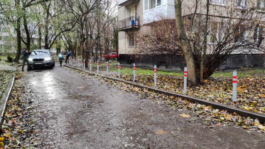 Ряд ограничительных столбиков вдоль тротуара во дворе жилого дома