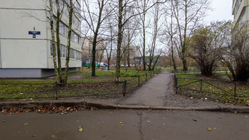 Пешеходная дорожка во дворе жилого дома с металлическими ограждениями