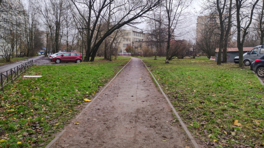 Пешеходная тропа в зелёной зоне жилого квартала осенью