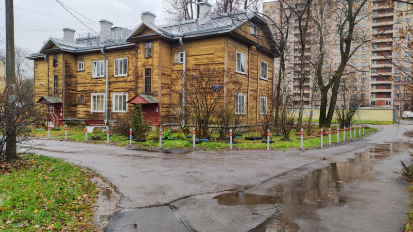 Старый деревянный жилой дом на фоне многоэтажек