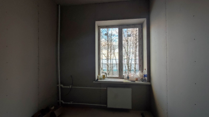 Комната на этапе черновой отделки с видом из окна