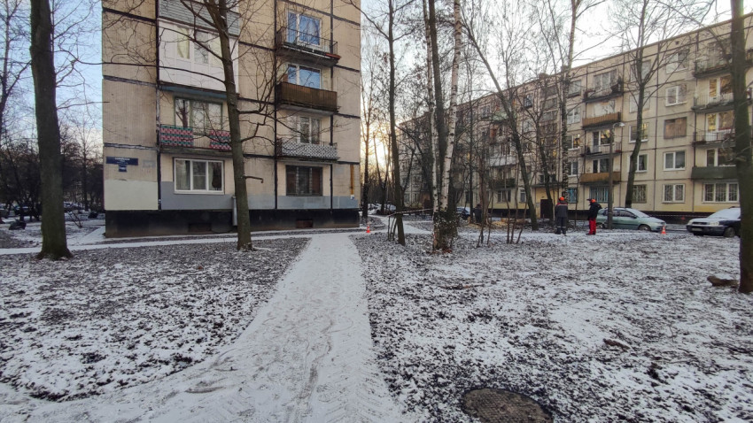Рабочие проводят благоустройство дворовой территории возле жилого дома в зимний период