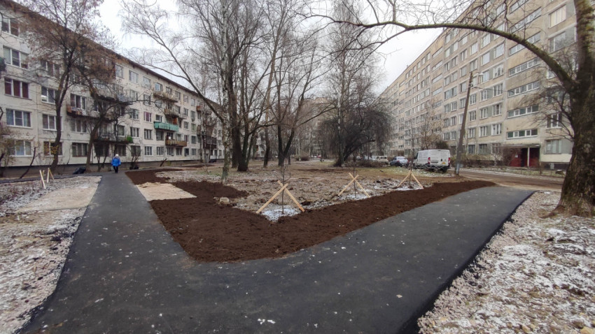 Дворовая территория после благоустройства с асфальтированными дорожками и подготовленной почвой