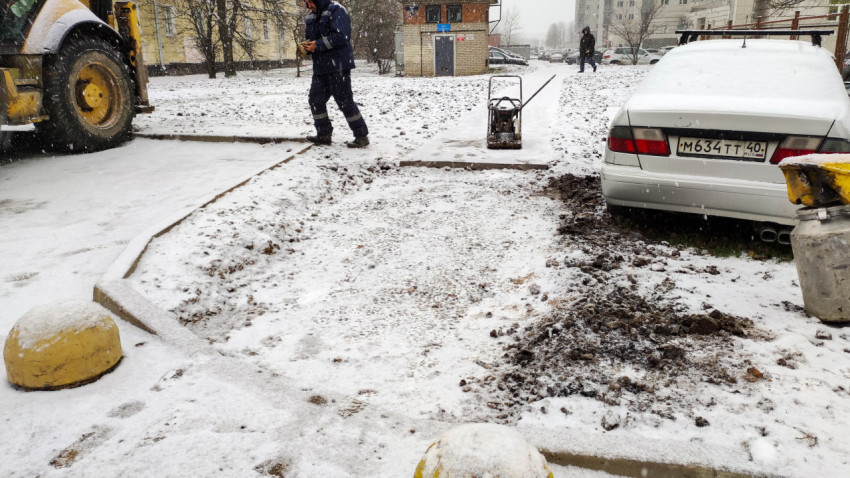 Частично уложенный асфальт на тротуаре в процессе строительства зимой