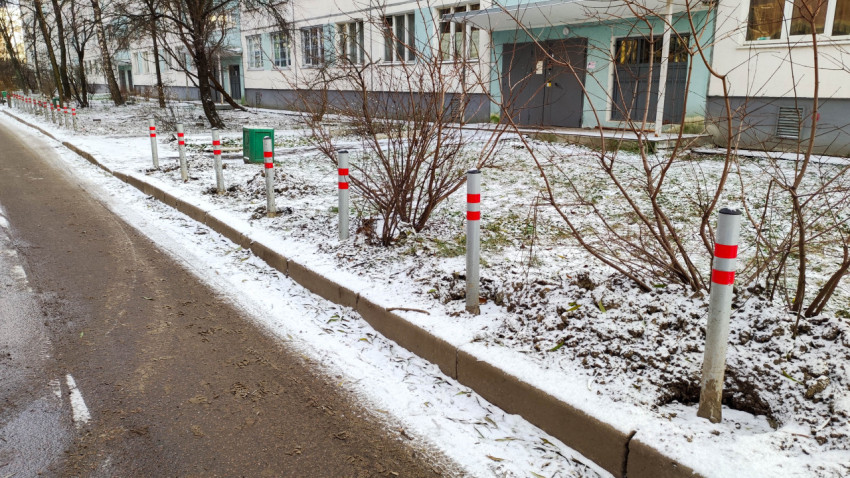 Ограничительные столбики вдоль дороги у жилого дома