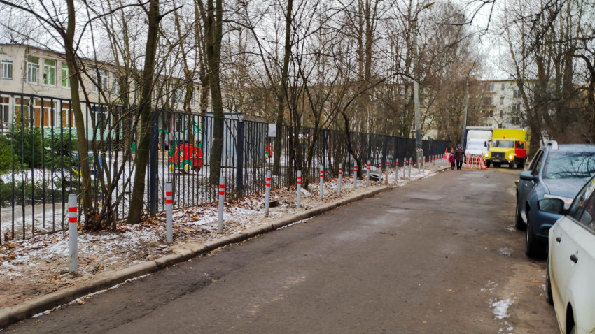 Ряд антипарковочных столбиков вдоль дороги у детсада