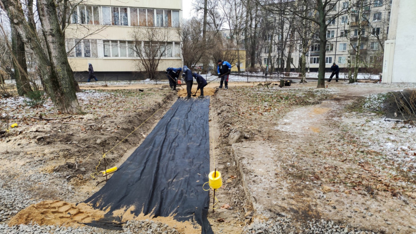 Укладка песчаного слоя на геотекстиль при строительстве дорожки