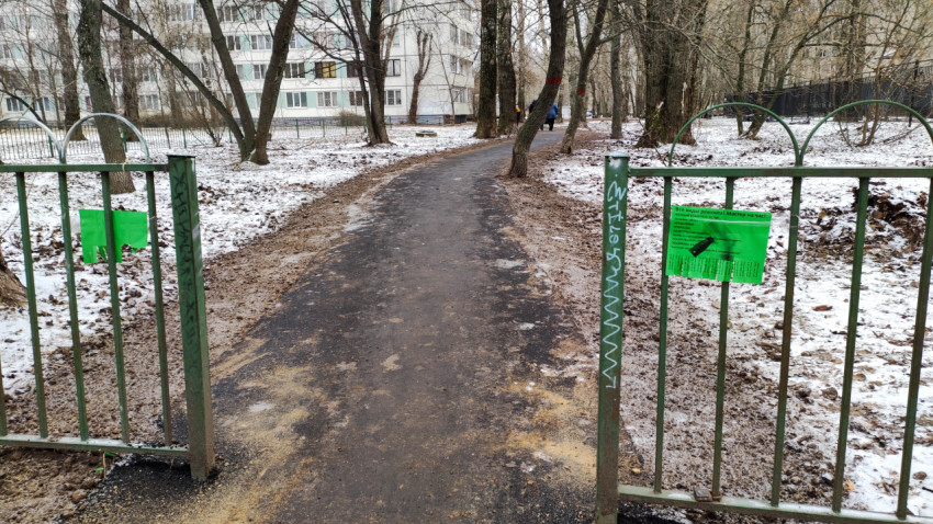 Зимняя дворовая пешеходная дорожка с металлическими воротами
