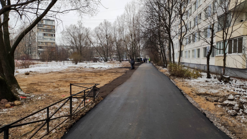 Пешеходная дорожка вдоль жилого дома зимой