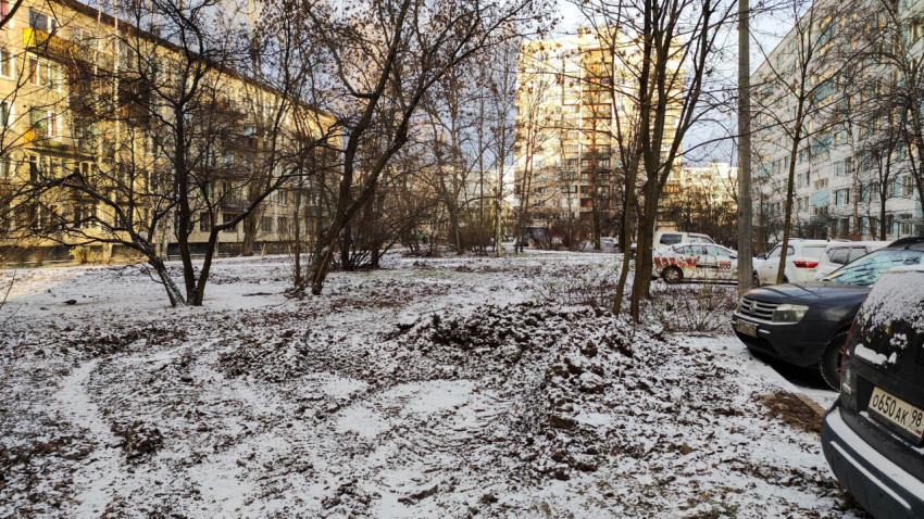 Заснеженный двор с остатками земляных работ в жилом квартале