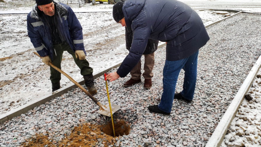 Проверка толщины основания пешеходной дорожки с помощью рулетки
