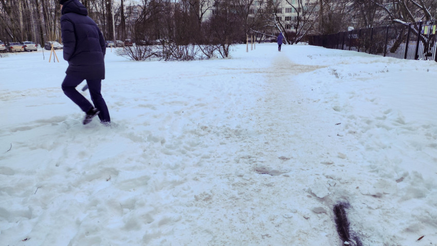 Заснеженная тропинка во дворе многоквартирного дома