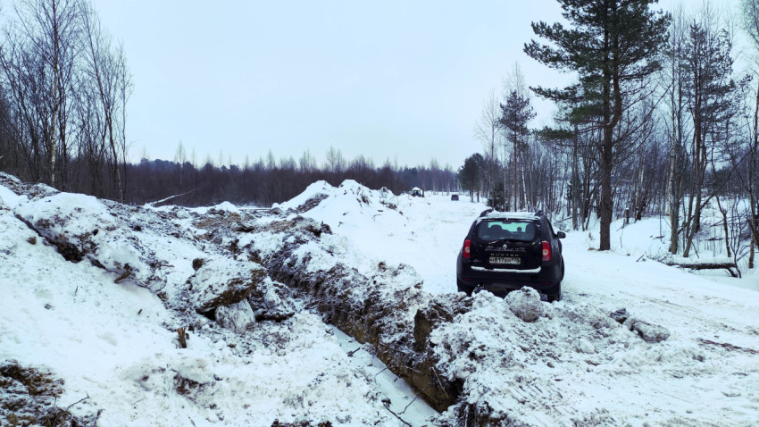 Автомобиль на заснеженной дороге у стройплощадки