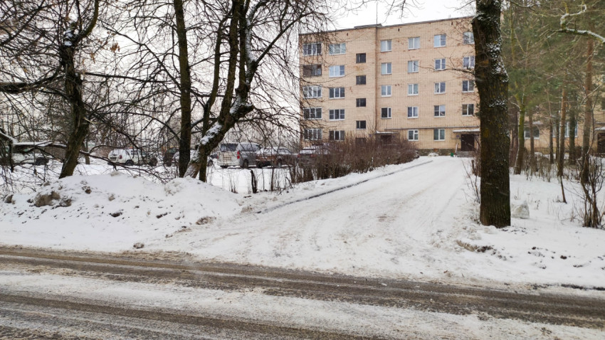 Заснеженный въезд во двор жилого дома зимой