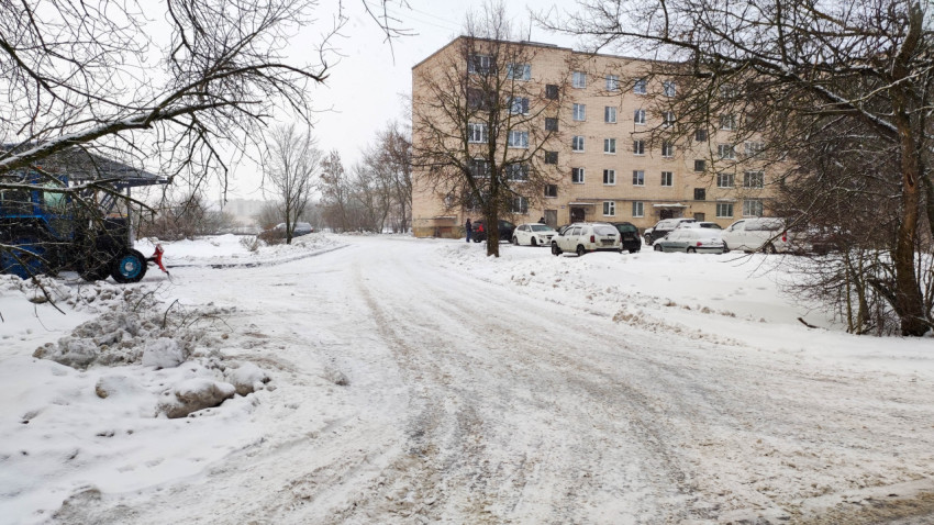 Заснеженная дорога у многоквартирного дома зимой