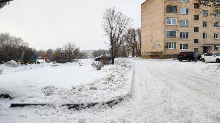 Заснеженный двор многоквартирного дома зимой